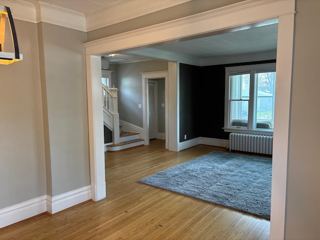 304 7th Pl NW, Austin, MN 55912 - unfurnished room with radiator, baseboards, wood-type flooring, ornamental molding, and stairs