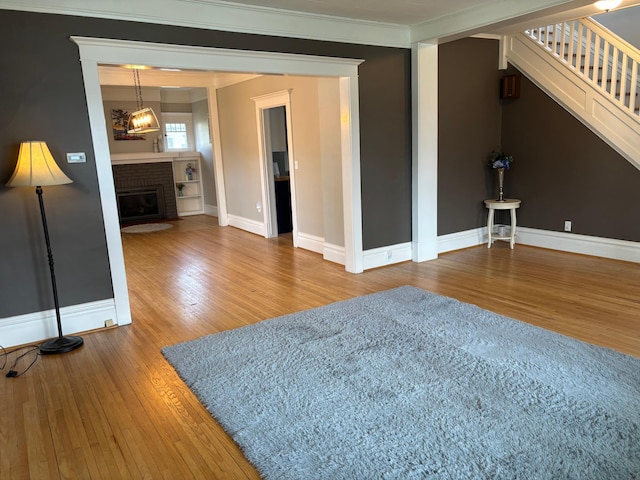 304 7th Pl NW, Austin, MN 55912 - living area featuring wood finished floors, crown molding, baseboards, and stairway