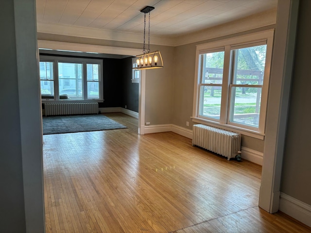304 7th Pl NW, Austin, MN 55912 - unfurnished dining area featuring radiator heating unit, ornamental molding, healthy amount of natural light, and a chandelier
