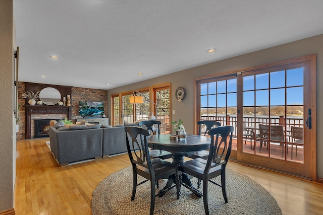 3202 Riviera Rd, Sartell, MN 56377 - dining area with light wood-style floors, recessed lighting, and a brick fireplace