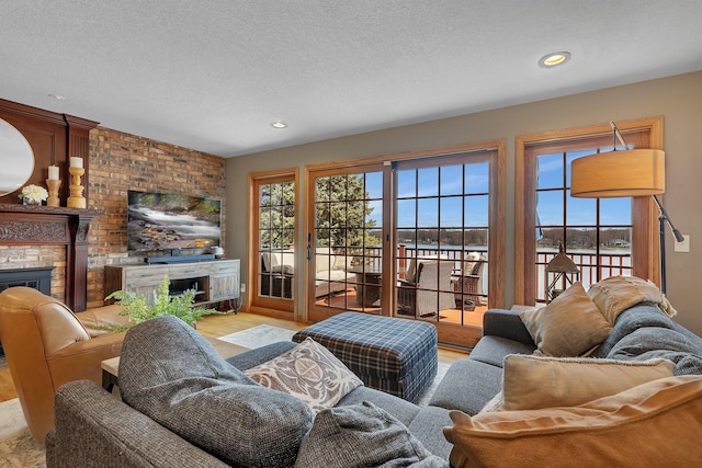 3202 Riviera Rd, Sartell, MN 56377 - living room with a textured ceiling, a fireplace, recessed lighting, and light wood-style flooring