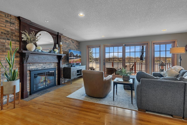 3202 Riviera Rd, Sartell, MN 56377 - living room with recessed lighting, a textured ceiling, wood finished floors, and a fireplace