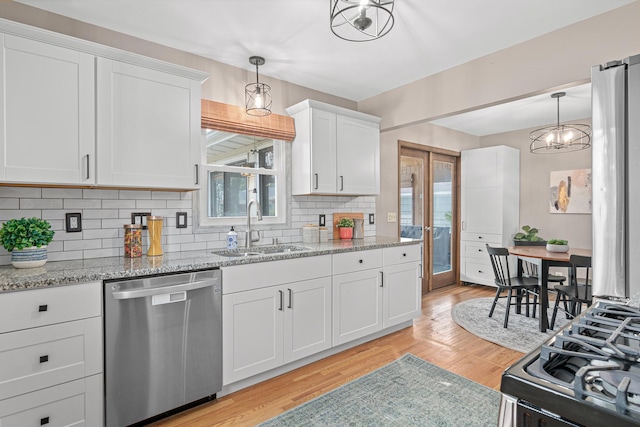 7244 12th Ave S, Richfield, MN 55423 - kitchen with stainless steel dishwasher, gas stove, backsplash, light wood-style flooring, and white cabinets