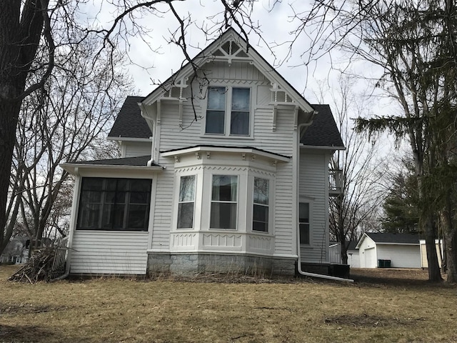 view of front of house with a shingled roof and a sunroom