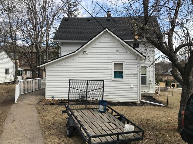 back of house with roof with shingles