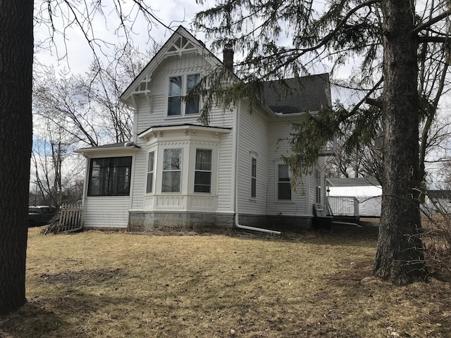 view of front of home with a chimney and a sunroom