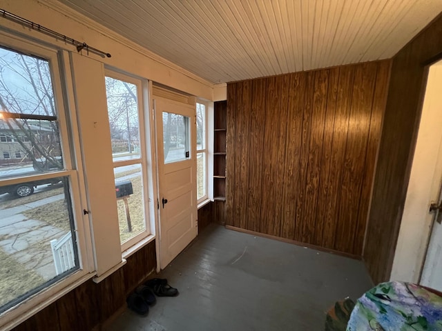 doorway with wood walls and wooden ceiling