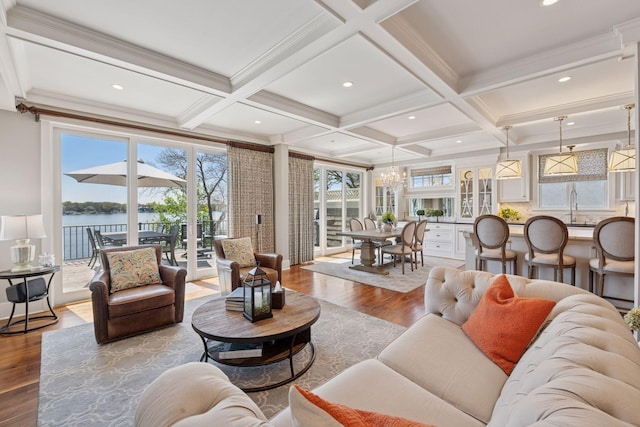 living room featuring beamed ceiling, an inviting chandelier, coffered ceiling, and wood finished floors
