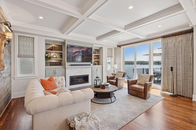 living room with wood finished floors, coffered ceiling, baseboards, beamed ceiling, and a glass covered fireplace