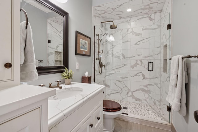 full bath featuring vanity, toilet, and a shower stall