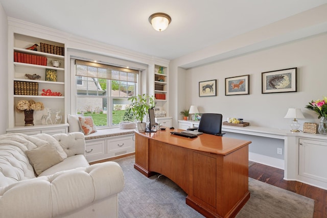 office area featuring dark wood-style flooring and built in shelves