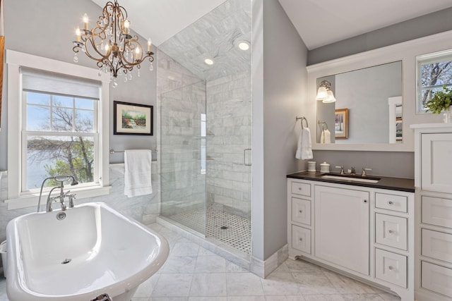 full bathroom featuring marble finish floor, vaulted ceiling, a stall shower, a chandelier, and a soaking tub