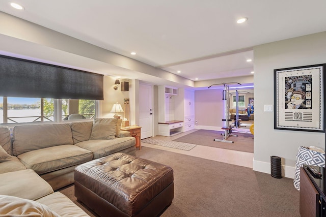 living room featuring carpet, a water view, baseboards, and recessed lighting
