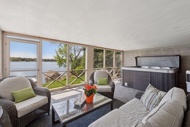 sunroom featuring a water view, outdoor lounge area, a jacuzzi, and a healthy amount of sunlight
