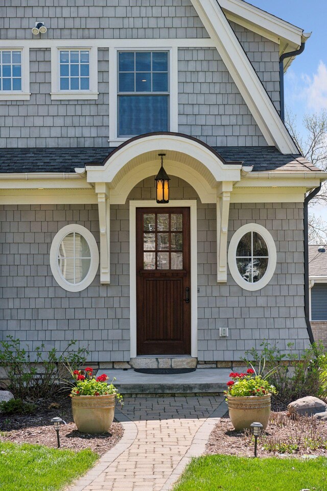 doorway to property with a shingled roof