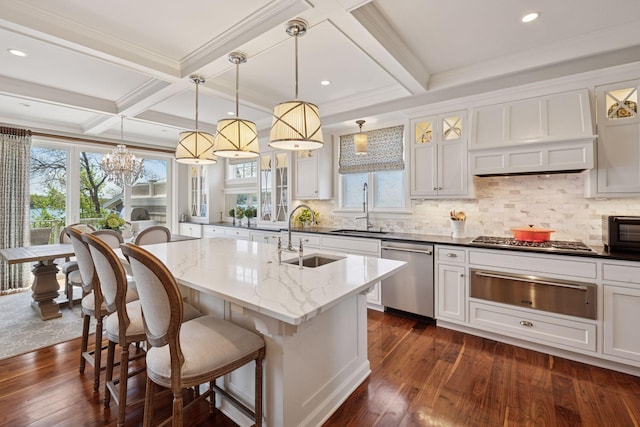 kitchen featuring an inviting chandelier, appliances with stainless steel finishes, a warming drawer, and a sink
