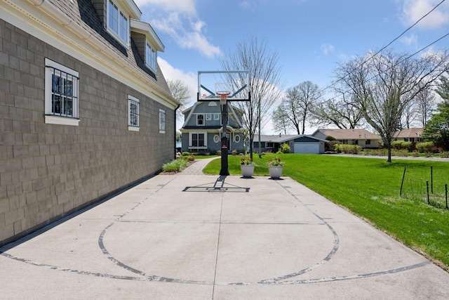 view of sport court featuring a lawn