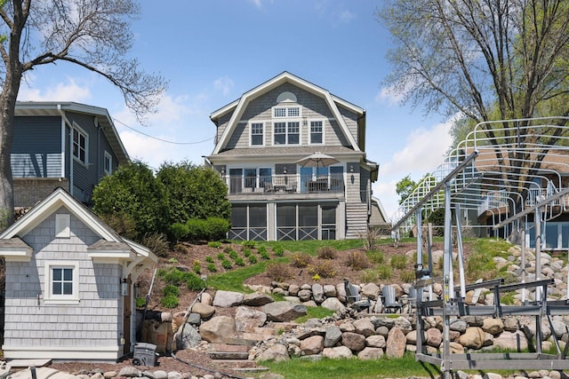 rear view of house featuring stairway and a balcony