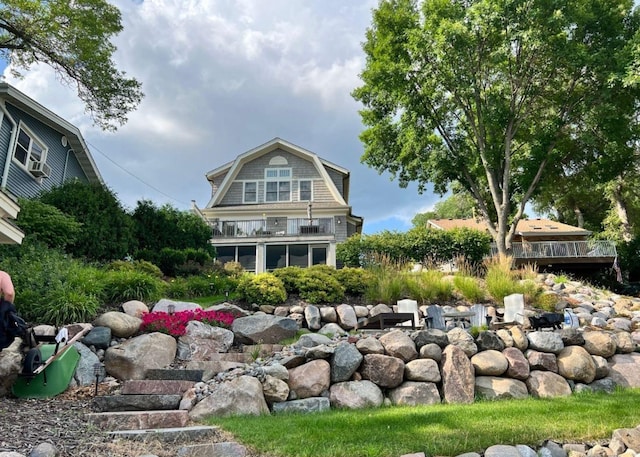 exterior space featuring a gambrel roof and a balcony
