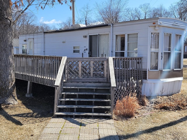 back of house featuring a wooden deck and stairway