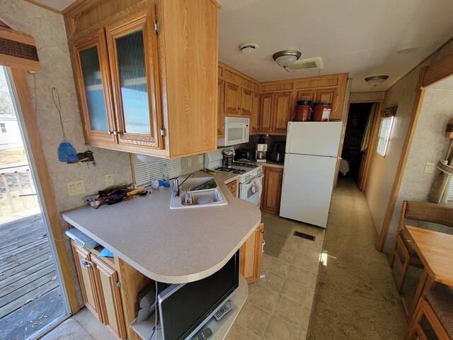 kitchen with light countertops, a sink, visible vents, and white appliances
