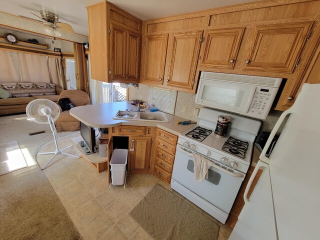 kitchen with light countertops, white appliances, a sink, open floor plan, and backsplash