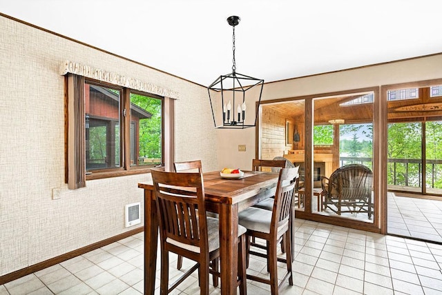 dining space featuring light tile patterned flooring, a healthy amount of sunlight, visible vents, and a chandelier