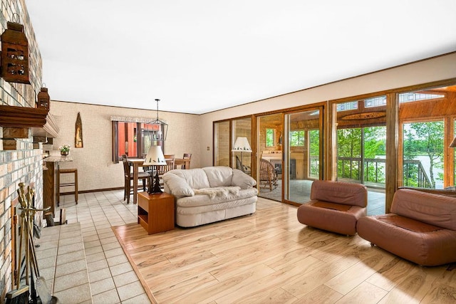 living area with light wood-style flooring, baseboards, and a fireplace