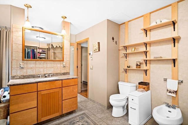 bathroom with decorative backsplash, toilet, vanity, a bidet, and tile patterned flooring