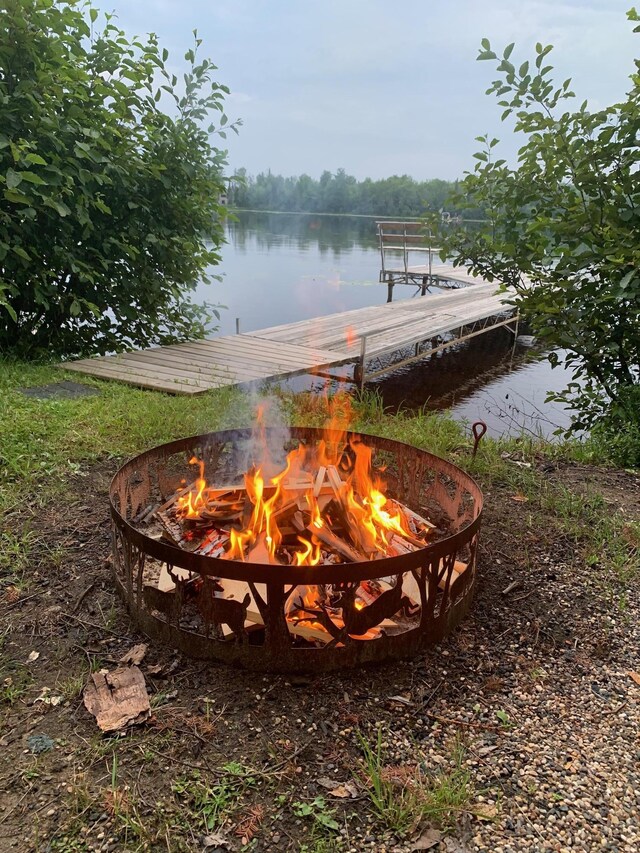 exterior space featuring an outdoor fire pit and a water view
