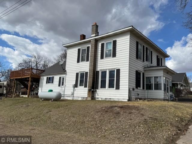 back of house with a deck and a chimney