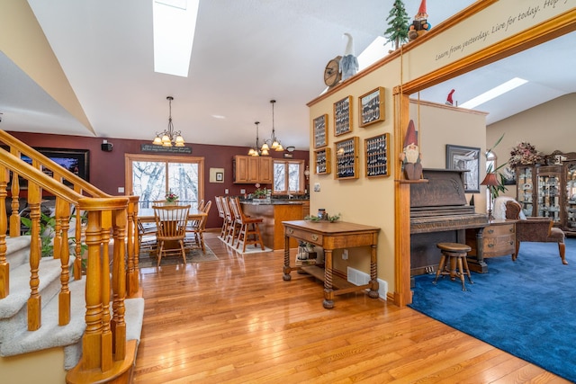 27192 237th Ave SW, Crookston Twp, MN 56716 - living area with a chandelier, light wood finished floors, a skylight, and vaulted ceiling