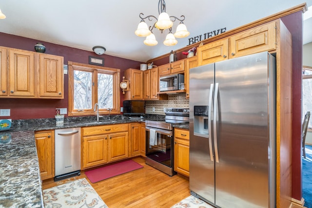 27192 237th Ave SW, Crookston Twp, MN 56716 - kitchen with stainless steel appliances, a sink, light wood-style flooring, a chandelier, and decorative backsplash