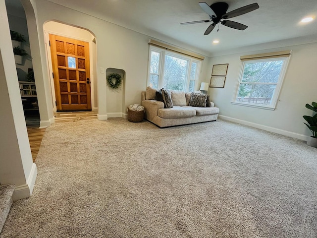 living area with plenty of natural light, baseboards, arched walkways, and ceiling fan
