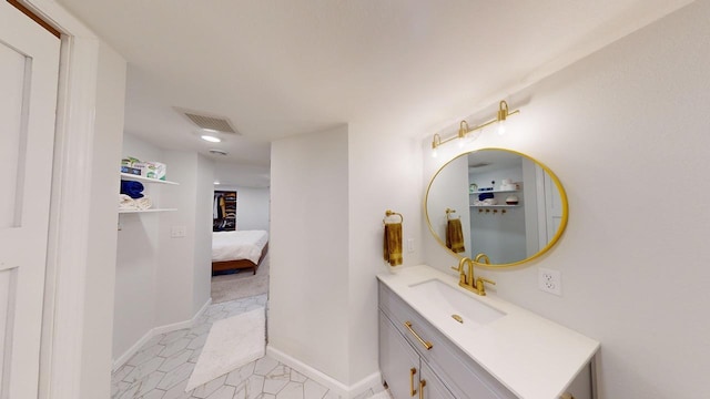 ensuite bathroom featuring vanity, baseboards, ensuite bathroom, and visible vents