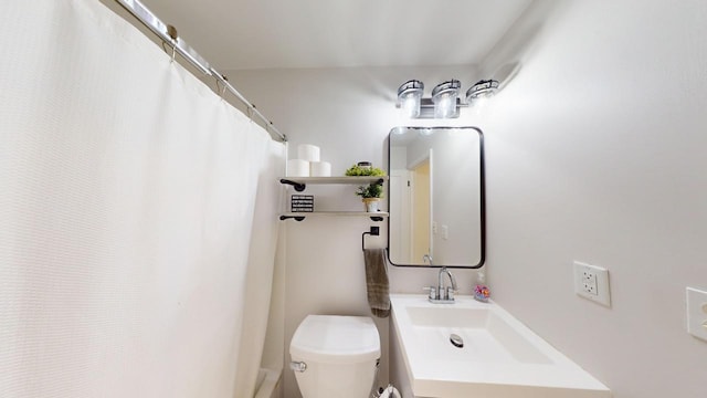 bathroom featuring toilet, a shower with shower curtain, and vanity