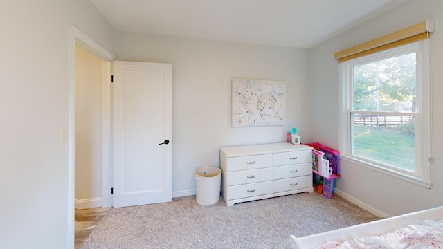bedroom featuring baseboards and light colored carpet