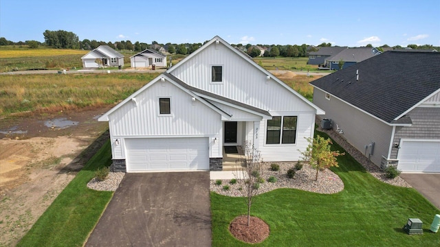 2133 Westpointe Dr, Hastings, MN 55033 - modern inspired farmhouse featuring asphalt driveway, a front yard, an attached garage, and board and batten siding