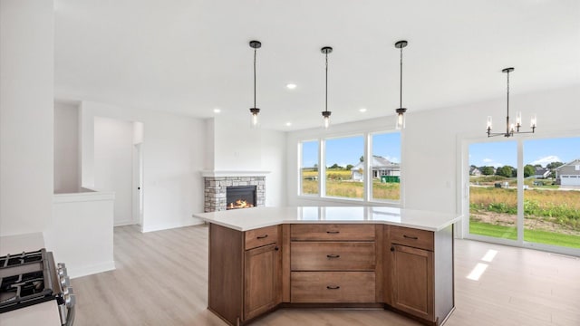 2133 Westpointe Dr, Hastings, MN 55033 - kitchen featuring stainless steel gas range oven, light wood-type flooring, a stone fireplace, light countertops, and recessed lighting