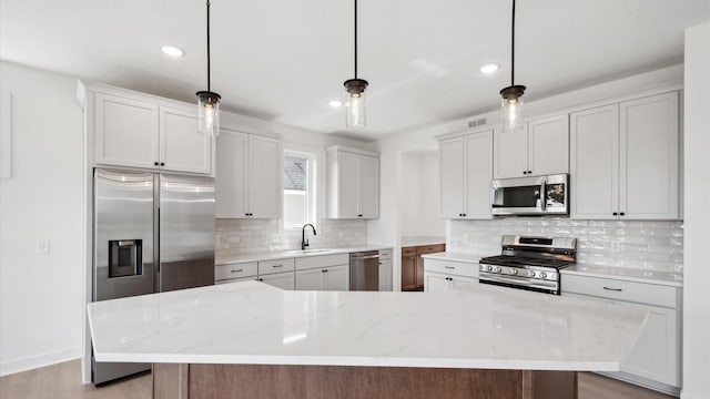 2133 Westpointe Dr, Hastings, MN 55033 - kitchen featuring appliances with stainless steel finishes, a sink, recessed lighting, tasteful backsplash, and light stone counters