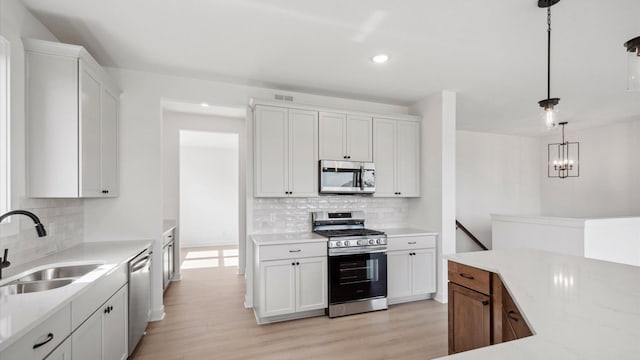 2133 Westpointe Dr, Hastings, MN 55033 - kitchen with stainless steel appliances, a sink, tasteful backsplash, light wood-style flooring, and recessed lighting