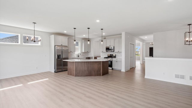 2133 Westpointe Dr, Hastings, MN 55033 - kitchen with stainless steel appliances, a chandelier, open floor plan, recessed lighting, and light wood finished floors