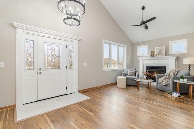 575 Elins Lake Rd SE, Cambridge, MN 55008 - foyer entrance with high vaulted ceiling, ceiling fan, a glass covered fireplace, baseboards, and light wood-style floors