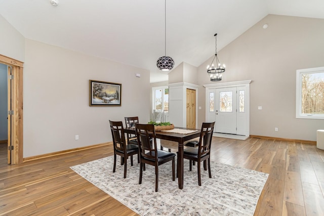 575 Elins Lake Rd SE, Cambridge, MN 55008 - dining area with light wood-style floors, a chandelier, high vaulted ceiling, and baseboards