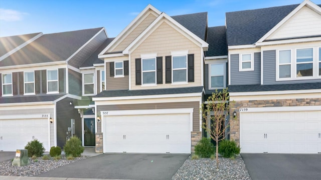 view of property featuring a garage, driveway, and stone siding