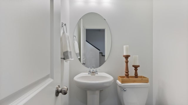 half bathroom featuring a sink and toilet