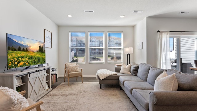 living room featuring recessed lighting, baseboards, visible vents, and wood finished floors