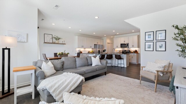 living area with recessed lighting, dark wood finished floors, and visible vents