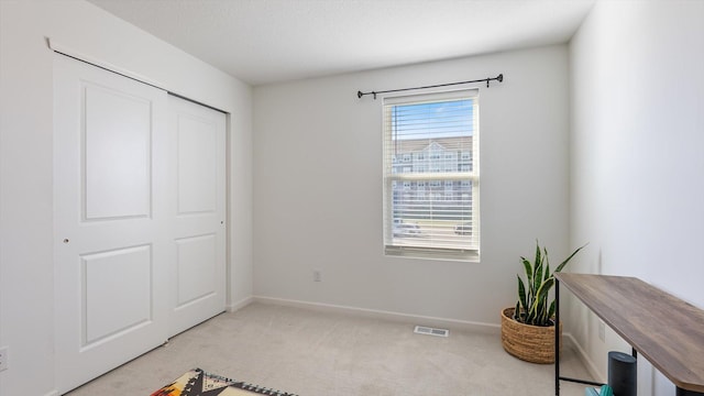 unfurnished bedroom featuring baseboards, carpet flooring, and visible vents