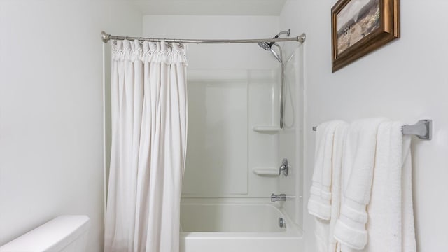 bathroom featuring toilet and shower / tub combo with curtain